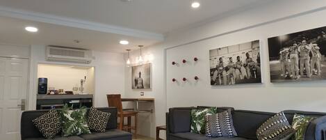 Una sala de estar moderna con un conjunto de sofá, una mesa de centro y un área de comedor con una silla y una mesa.