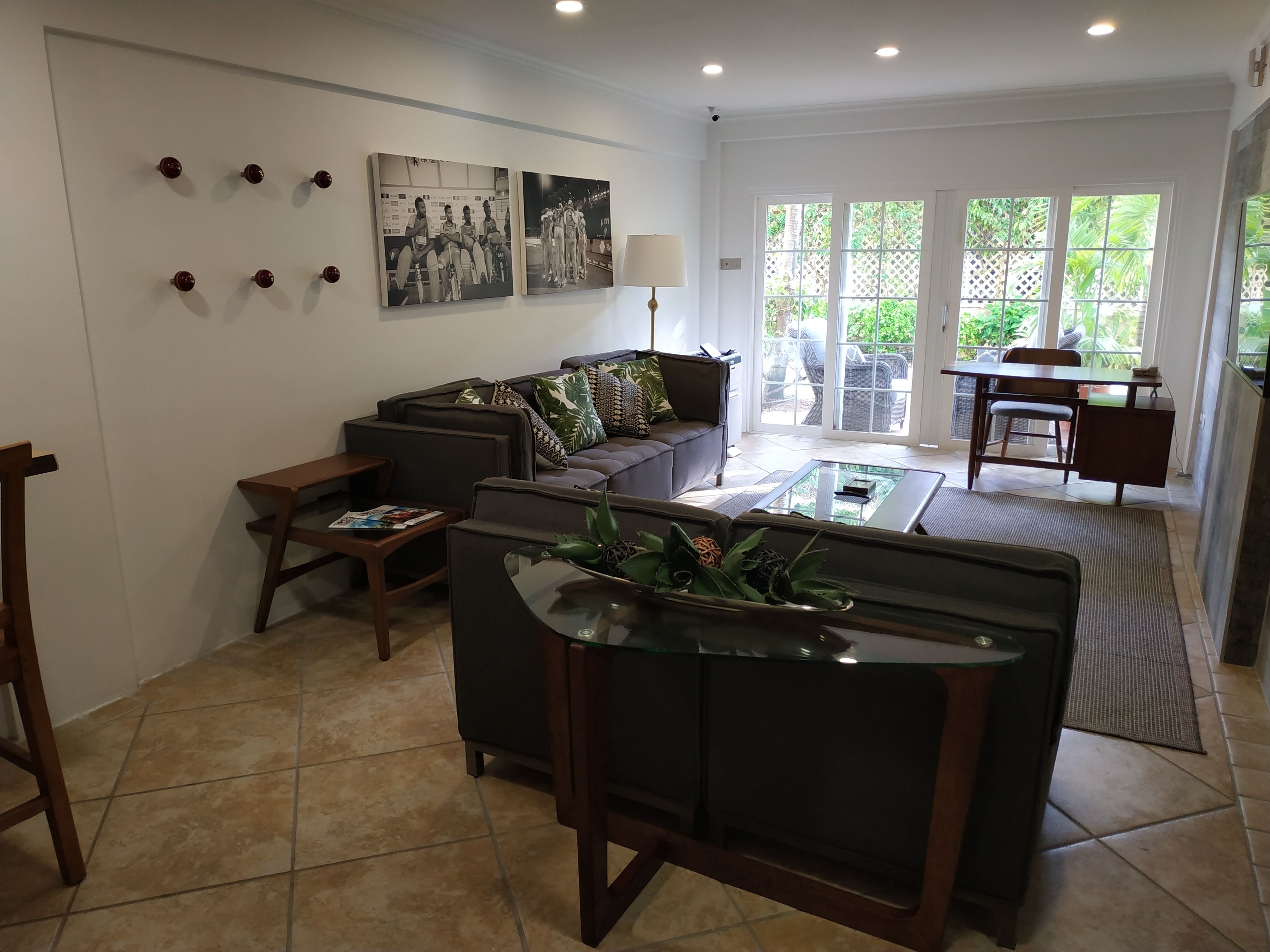 A modern living room with a sofa, coffee table, and a dining area with chairs.