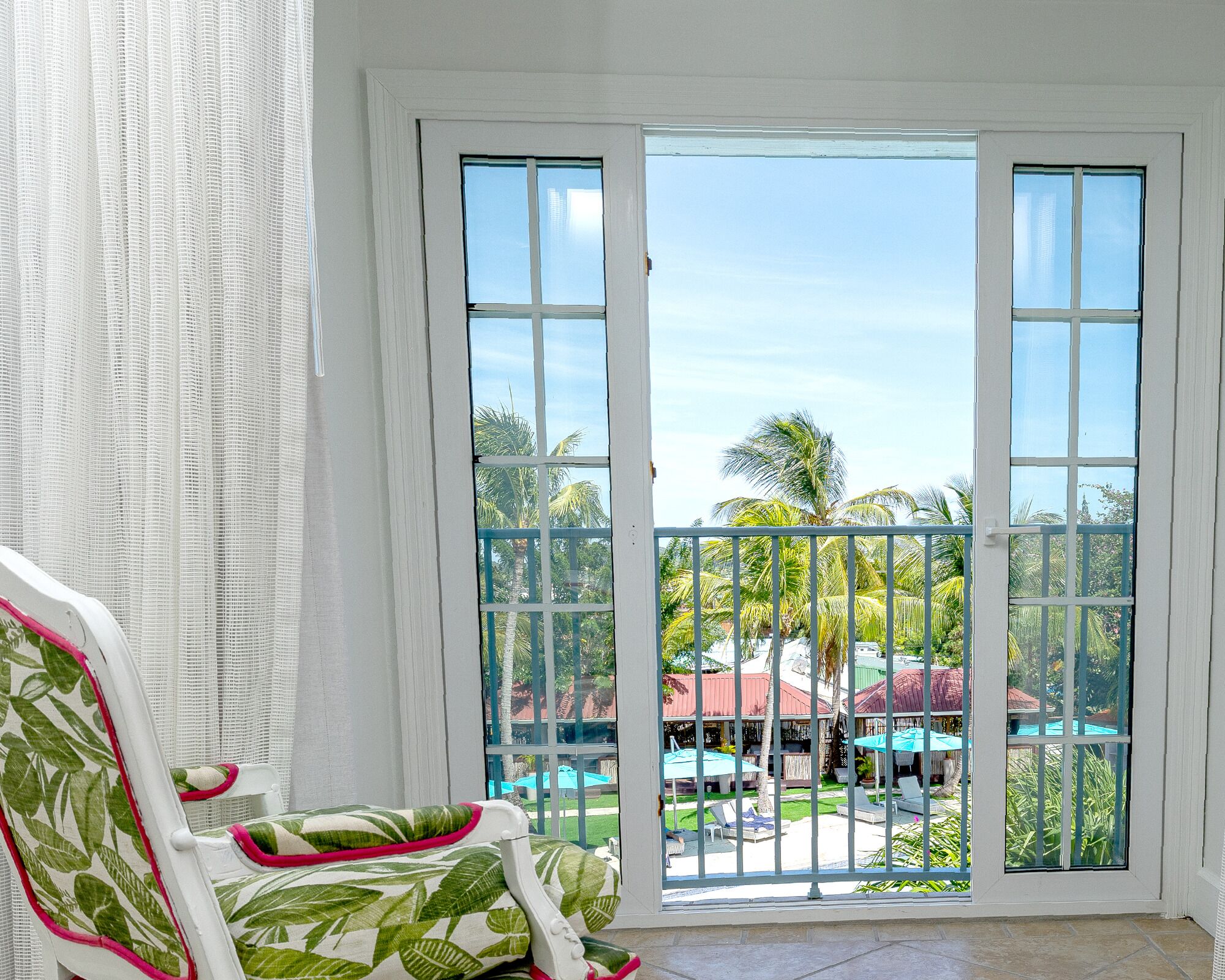 Habitación con vista a una piscina y palmeras.