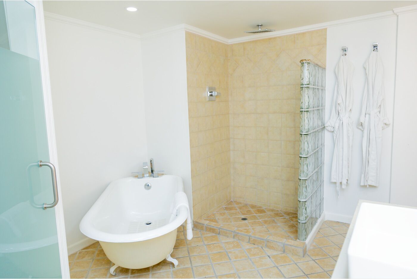 A bathroom with a freestanding bathtub, a shower area, and a glass shower enclosure.