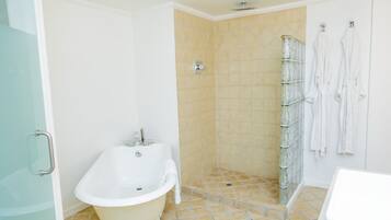 A bathroom with a freestanding bathtub, a shower area, and a glass shower enclosure.
