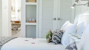 Un dormitorio con cama, armario, mesita de noche y lámpara.