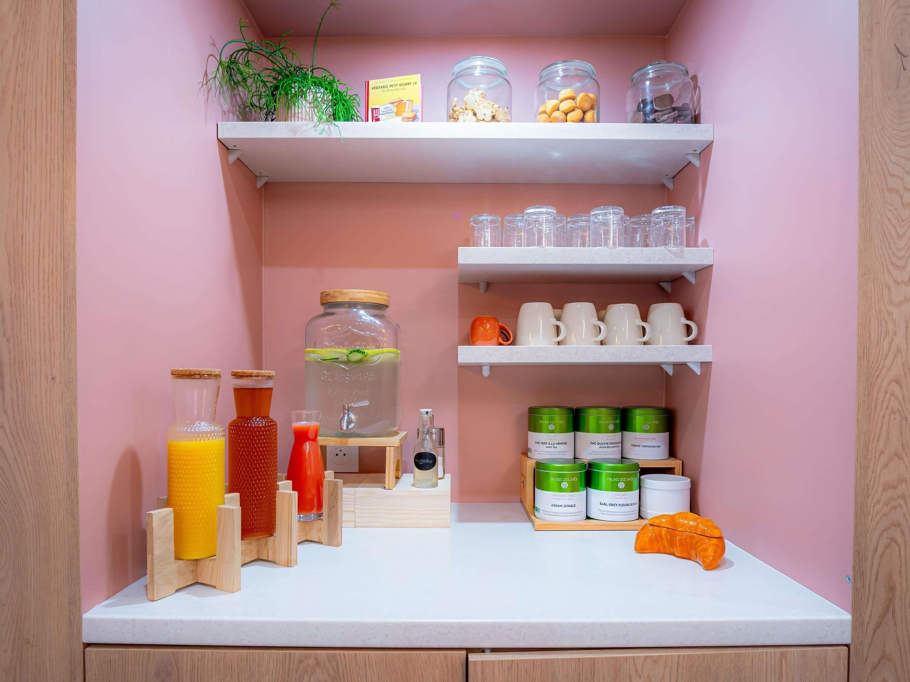 A kitchen with shelves holding jars, bottles, and mugs.
