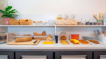 Un buffet de petit-déjeuner proposant une variété de pains, de viennoiseries et une plante.