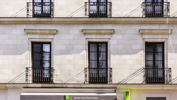 Un edificio con un cartel que dice "Nantes Centre Place Graslin" y un hidrante.