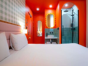 A hotel room with a bed, a bathroom with a shower, and a mirror. - ibis Styles Nantes Centre Place Graslin (Nantes)