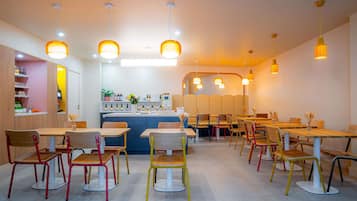 A restaurant with multiple dining areas, a bar, and a counter with a variety of beverages.