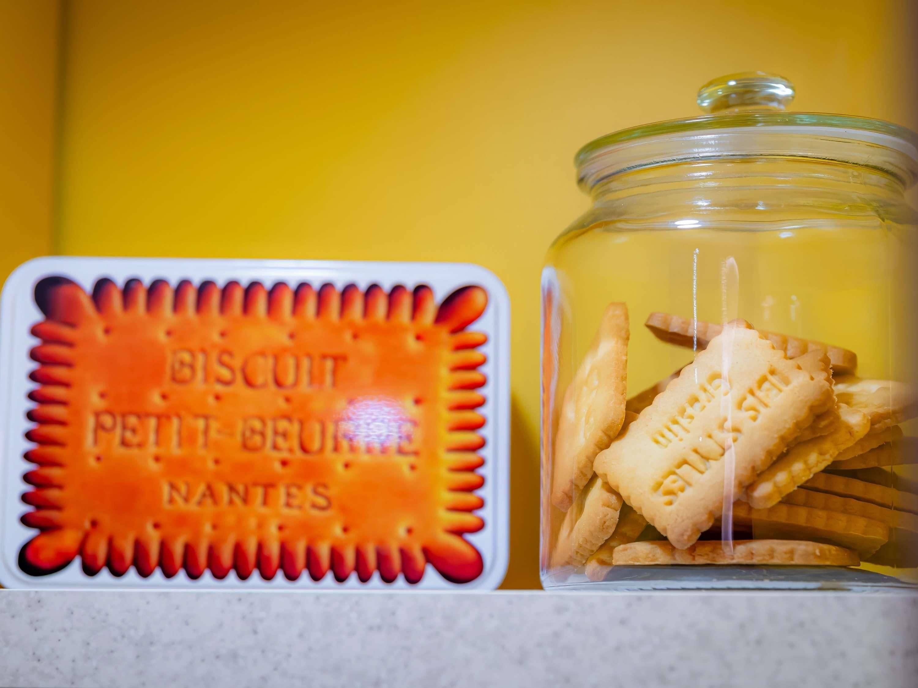 A biscuit tin labeled 'BISCUIT PETIT BEURRE NANTES' and a glass jar with biscuits.