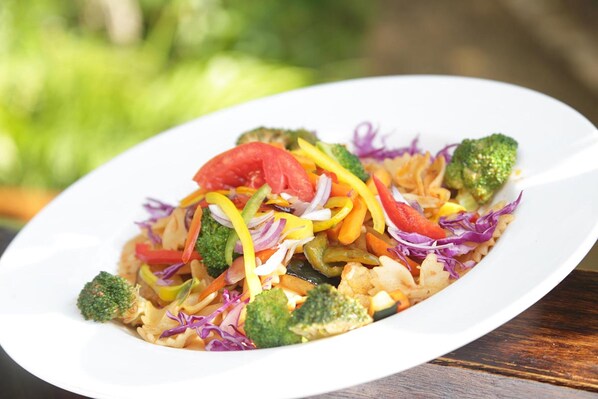 A white plate with a colorful vegetable stir-fry. - Tensing Pen Hotel (Negril)