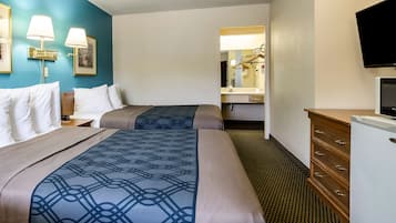 Une chambre d’hôtel avec deux lits, une commode, un téléviseur et un miroir.