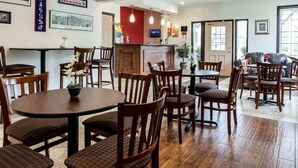 A restaurant with wooden tables and chairs, a counter with a menu, and framed pictures on the walls. - Econo Lodge Lawrence near University (Lawrence)