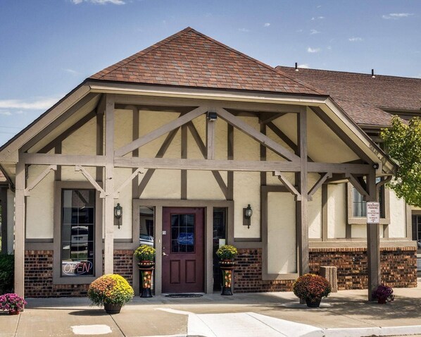 A building with a gabled roof, a central entrance with a door, and a sign indicating reserved parking. - Econo Lodge Lawrence near University (Lawrence)