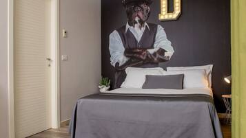 Una camera da letto con un letto, una lampada a parete, una porta e una piccola pianta.
