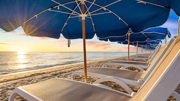 On the beach, white sand, sun loungers, beach umbrellas
