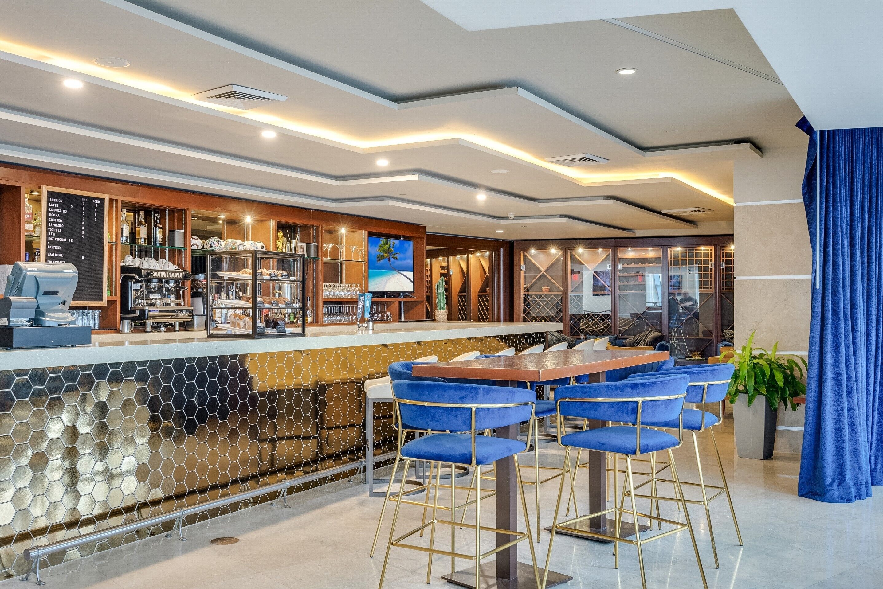 Un espace bar moderne avec un comptoir, des tabourets de bar et un tableau affichant le menu.