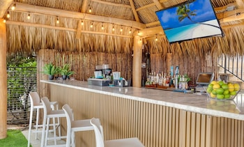 A spacious dining area with multiple tables and chairs, large windows, and chandeliers. at Marenas Beach Resort