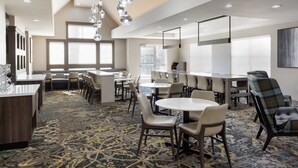A hotel dining area with round tables, chairs, and a patterned carpet. - Residence Inn by Marriott Corona Riverside (Corona)