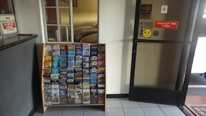 A travel information stand with brochures and a sign indicating check-out time. - Budget Inn San Gabriel (San Gabriel)