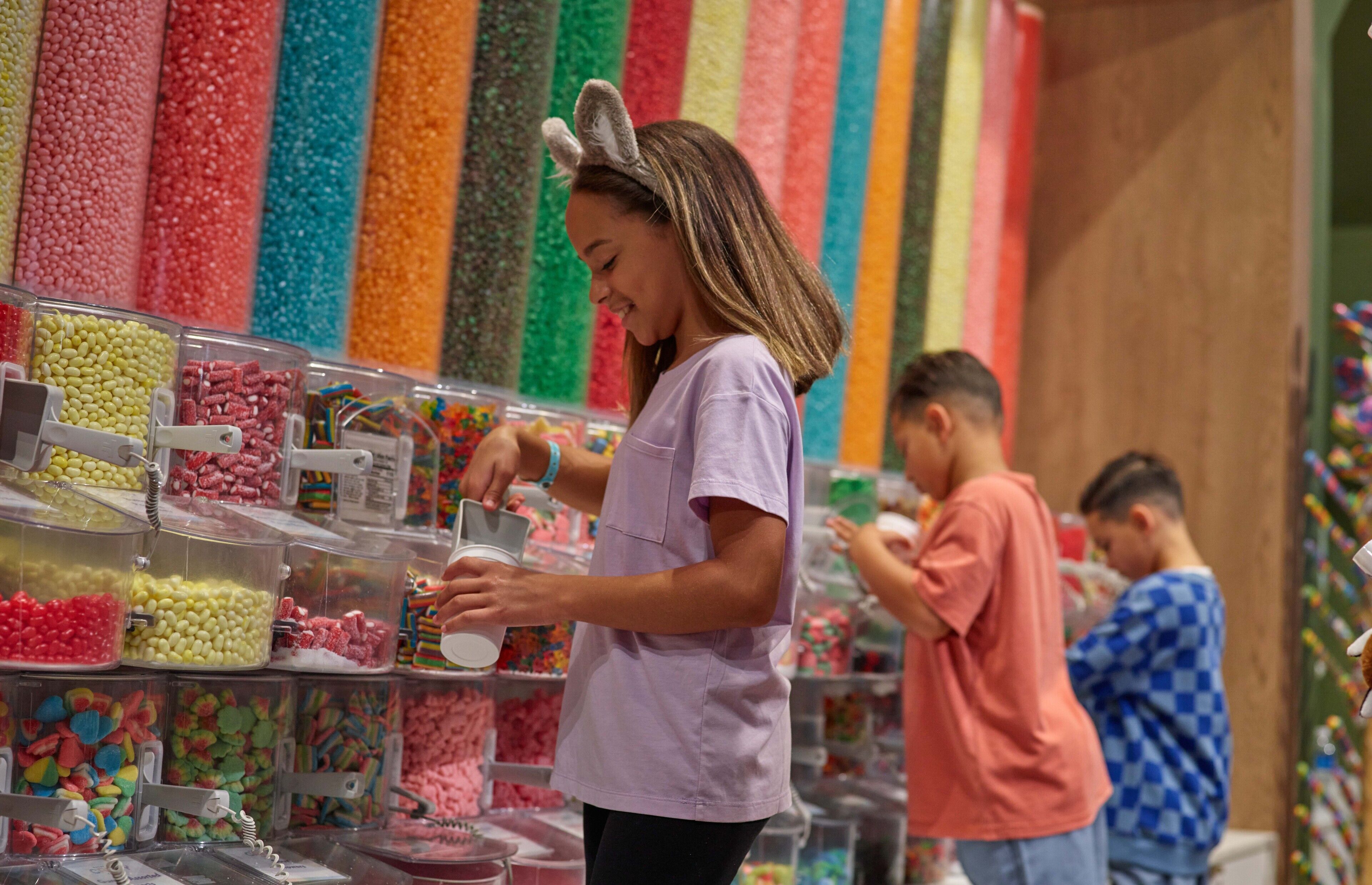 Une confiserie où l’on trouve toutes sortes de bonbons colorés présentés dans des récipients transparents.