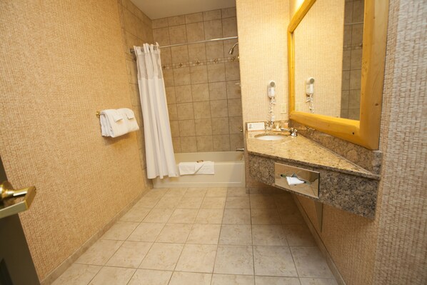 Un baño con bañera, lavamanos, espejo y cortina de ducha.