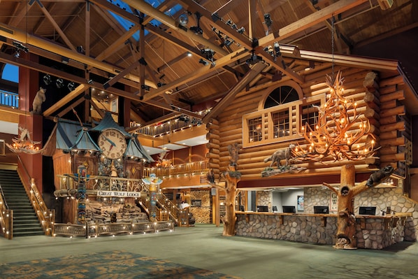 A log cabin-style building with a wooden interior, a central staircase, and a reception desk. - Great Wolf Lodge Wisconsin Dells (Baraboo)