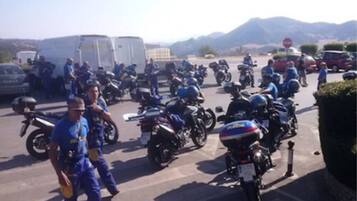 Un estacionamiento con varias motocicletas y algunas personas.