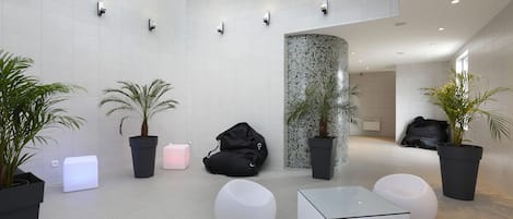 Un vestíbulo moderno con paredes blancas, iluminación empotrada y mobiliario minimalista.
