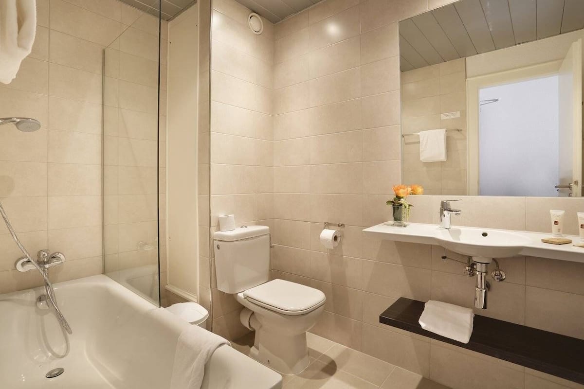Une salle de bain moderne équipée d’une baignoire, de toilettes et d’un lavabo.