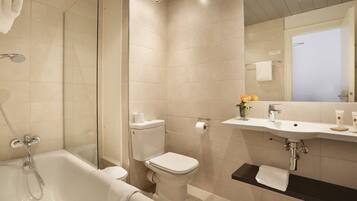 A modern bathroom with a bathtub, toilet, and sink.