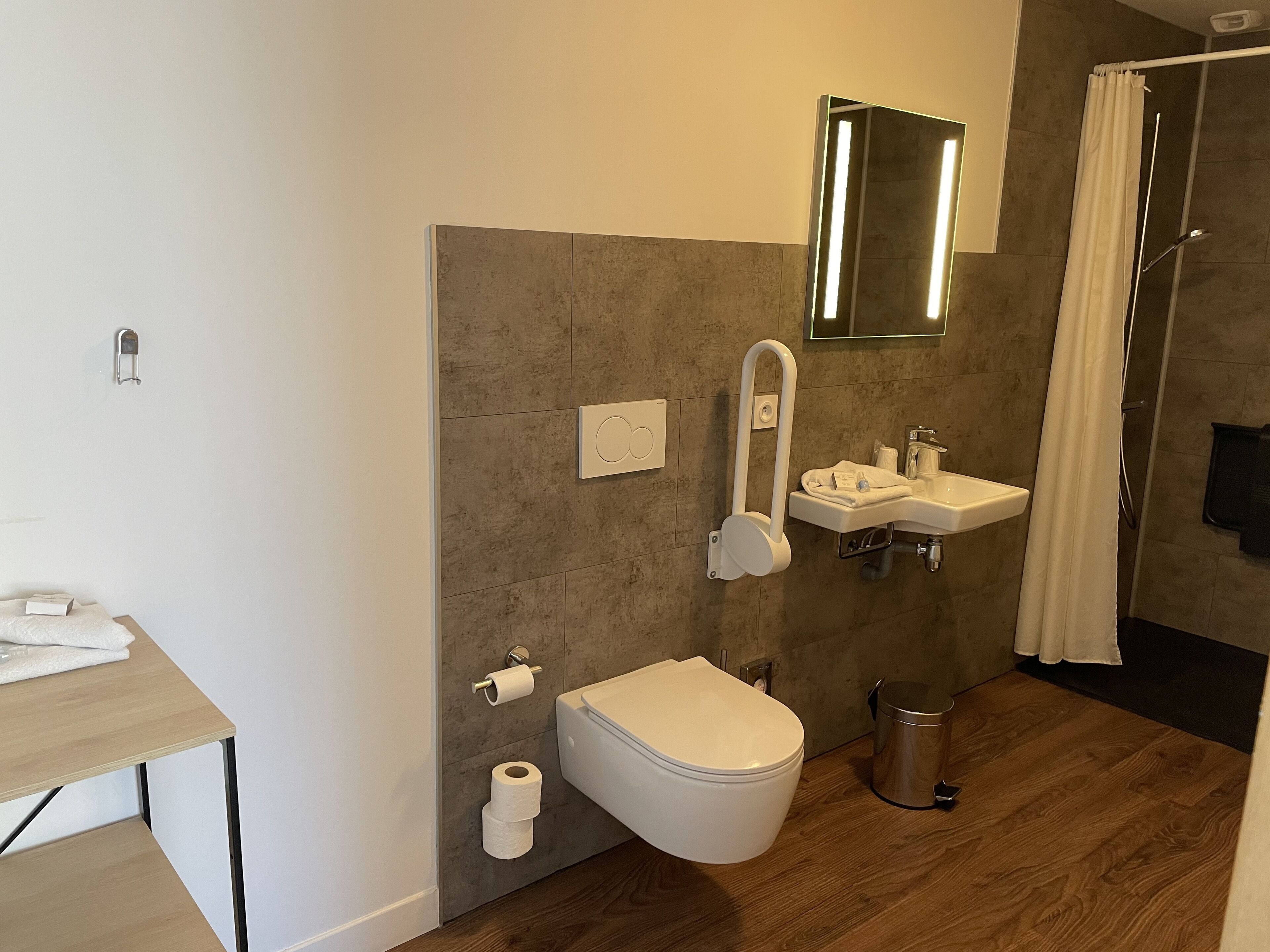 Un baño moderno con inodoro, lavamanos y ducha.