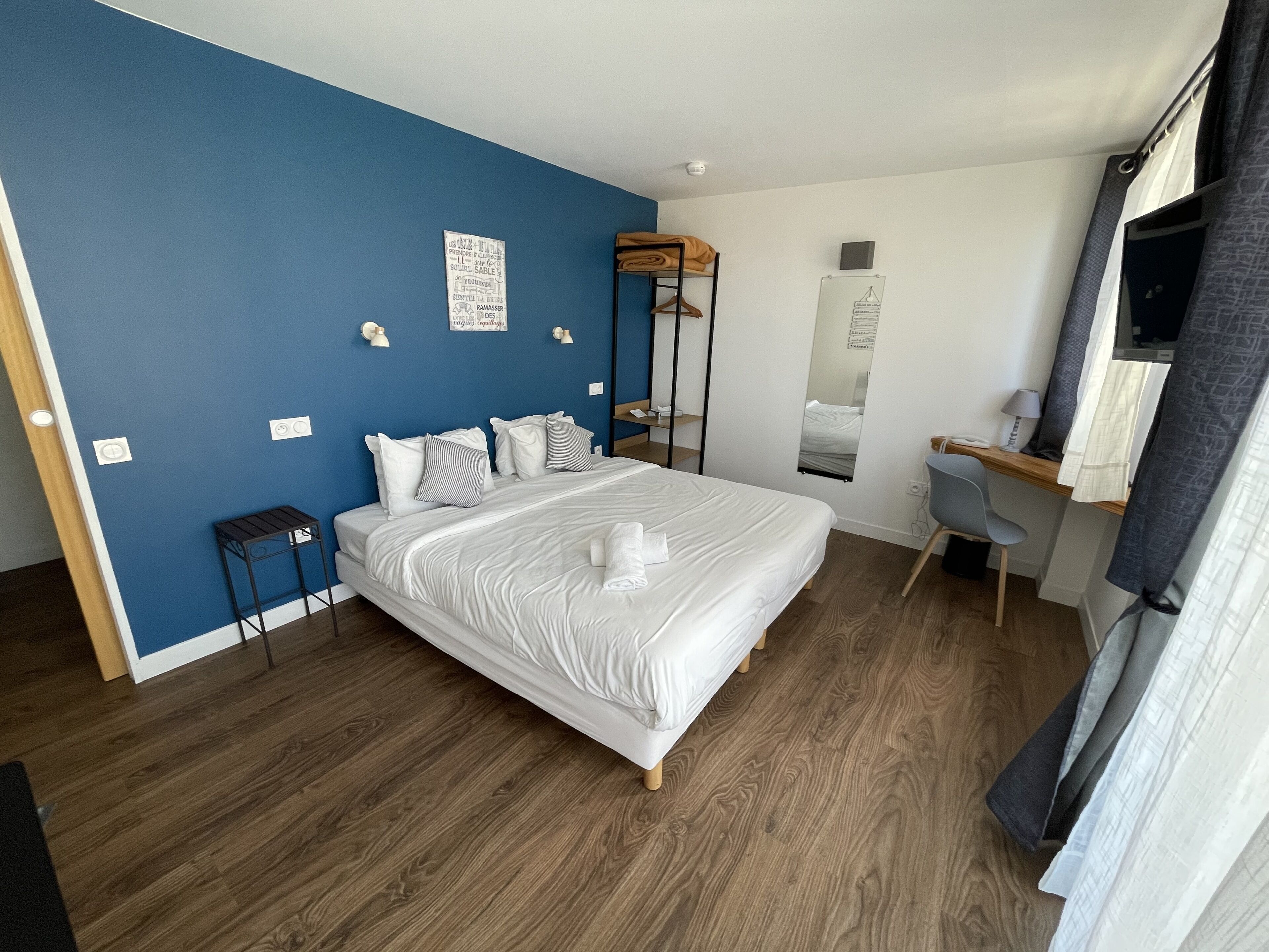 Une chambre à coucher moderne avec un grand lit, un bureau et une chaise.