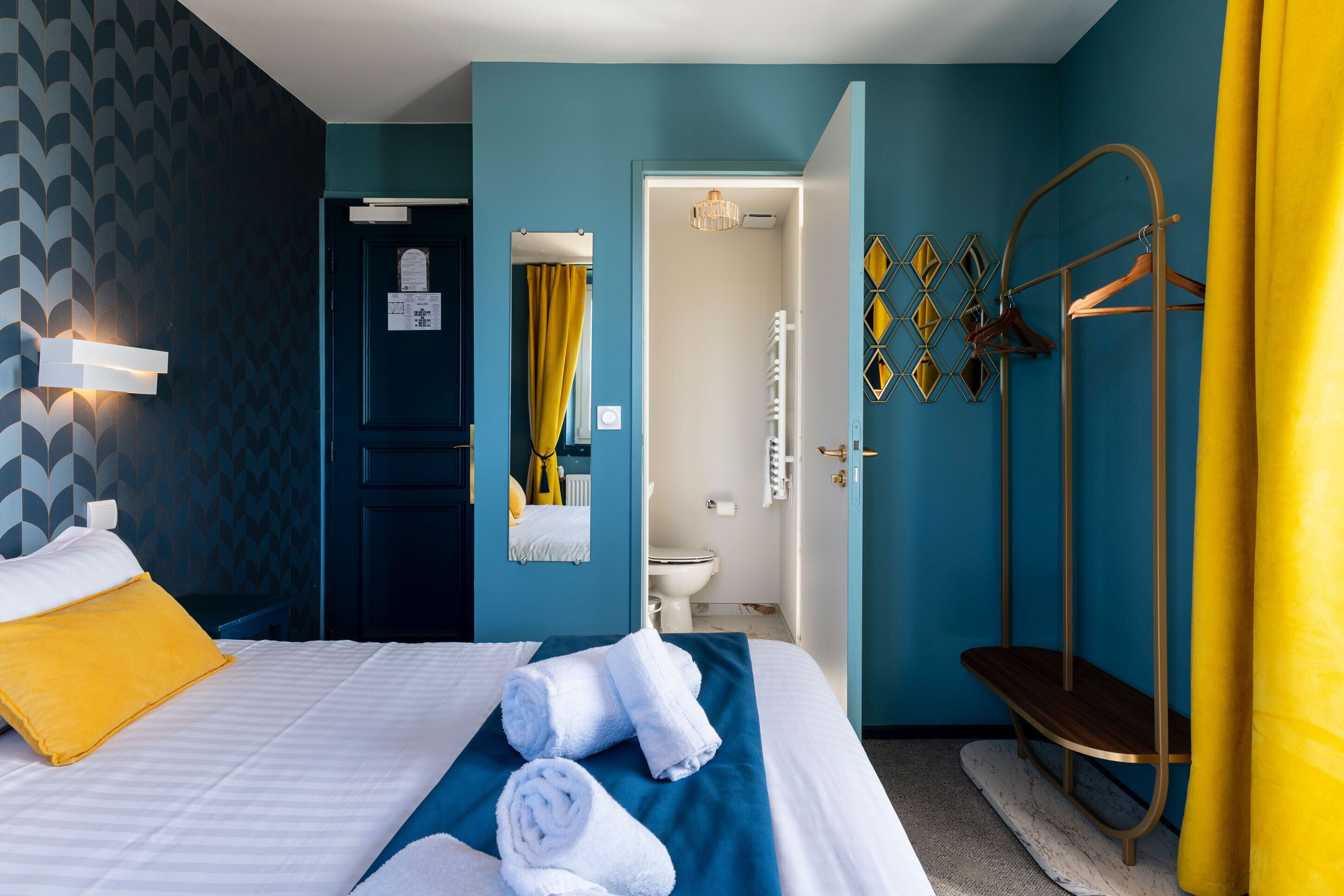 A hotel room with a bed, a bathroom, and a shower area.