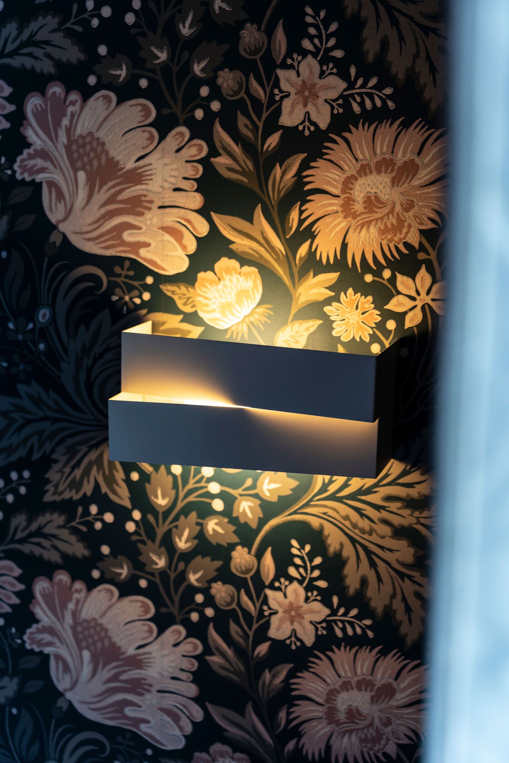 A wall-mounted light fixture with a rectangular shape and a flat surface.