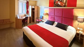 Habitació d'hotel amb un llit gran, un escriptori, una cadira i un armari.