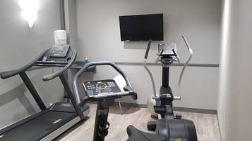A gym with two treadmills and an elliptical machine.