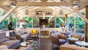 A modern living room with sofas, coffee tables, and pendant lights. - Hotel Acadie Villebon-sur-Yvette (Villebon-sur-Yvette)