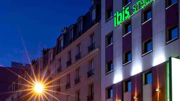 Een gebouw met een bord waarop 'ibis styles' staat en meerdere ramen.