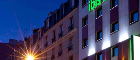 A building with a sign that reads 'ibis styles' and multiple windows.
