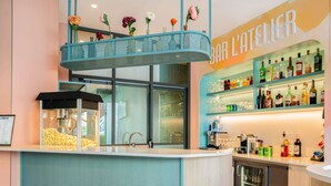 A bar area with a counter, a popcorn machine, and shelves of liquor bottles. - ibis Styles Paris Porte d’Orléans Hotel (Montrouge)