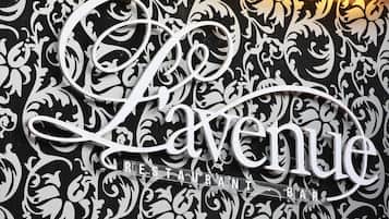 Un letrero decorativo con la palabra 'Lavenue' e 'RESTAURANT BAR' que indica un establecimiento para comer.