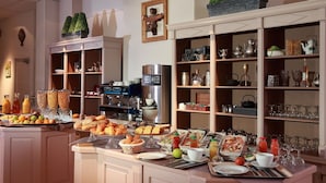 A breakfast buffet with various food items, a coffee machine, and glassware. - Hôtel Providence (Vittel)