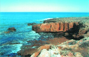 A coastal landscape with rocky terrain and the ocean. - Masseria Refrigerio (Ostuni)