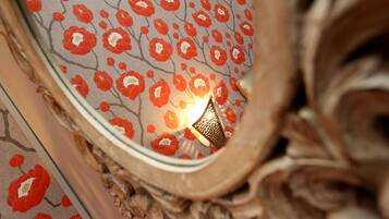 A close-up of a wall with a floral pattern and a decorative metal piece.