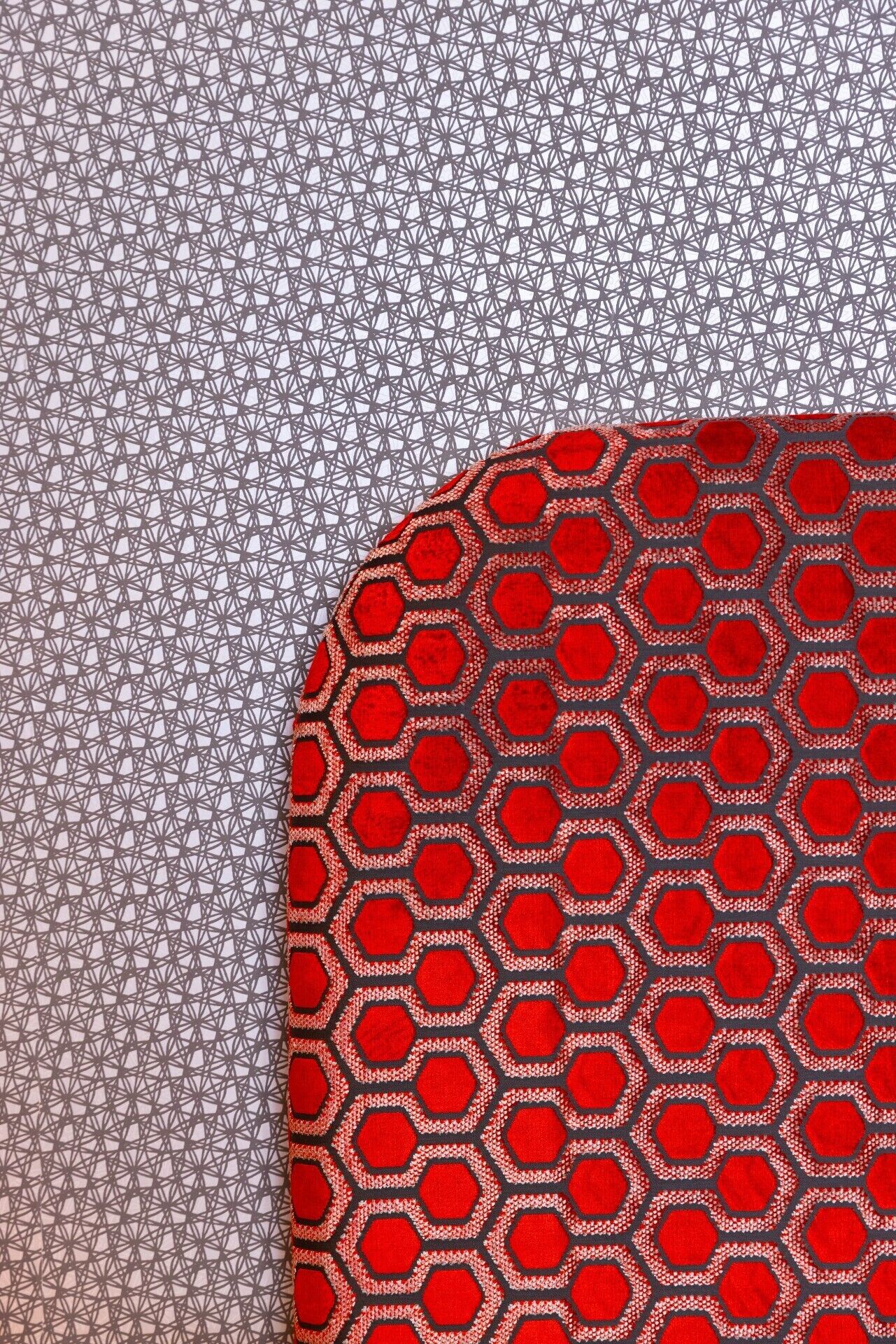 Stof met een geometrisch patroon in tinten grijs en rood.