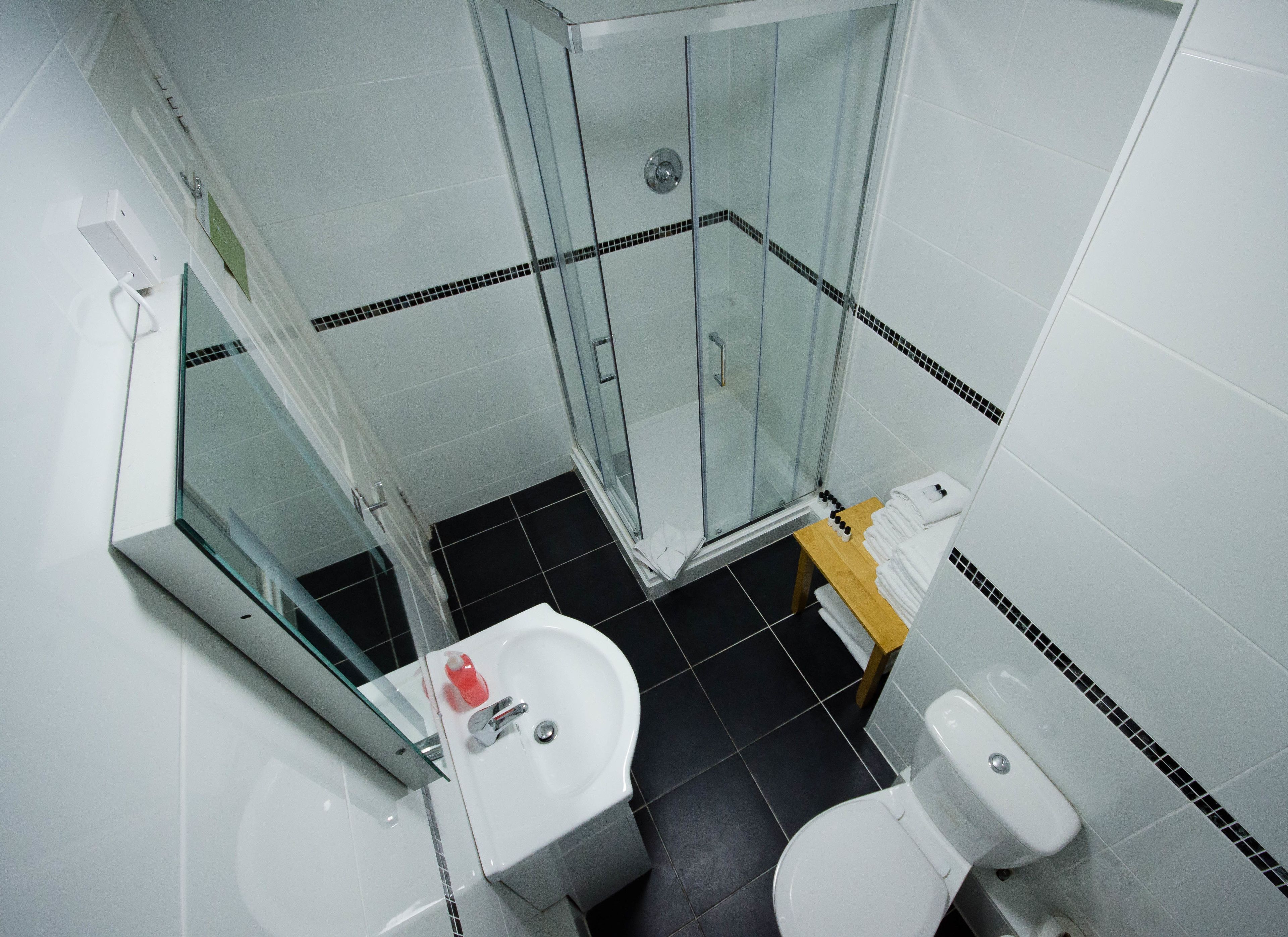 Une salle de bain moderne avec une douche à parois de verre, un lavabo blanc et des toilettes.