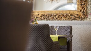 A dining area with a patterned chair, a table with a yellow tablecloth, and a wine glass. - The Club House Hotel (Kilkenny)