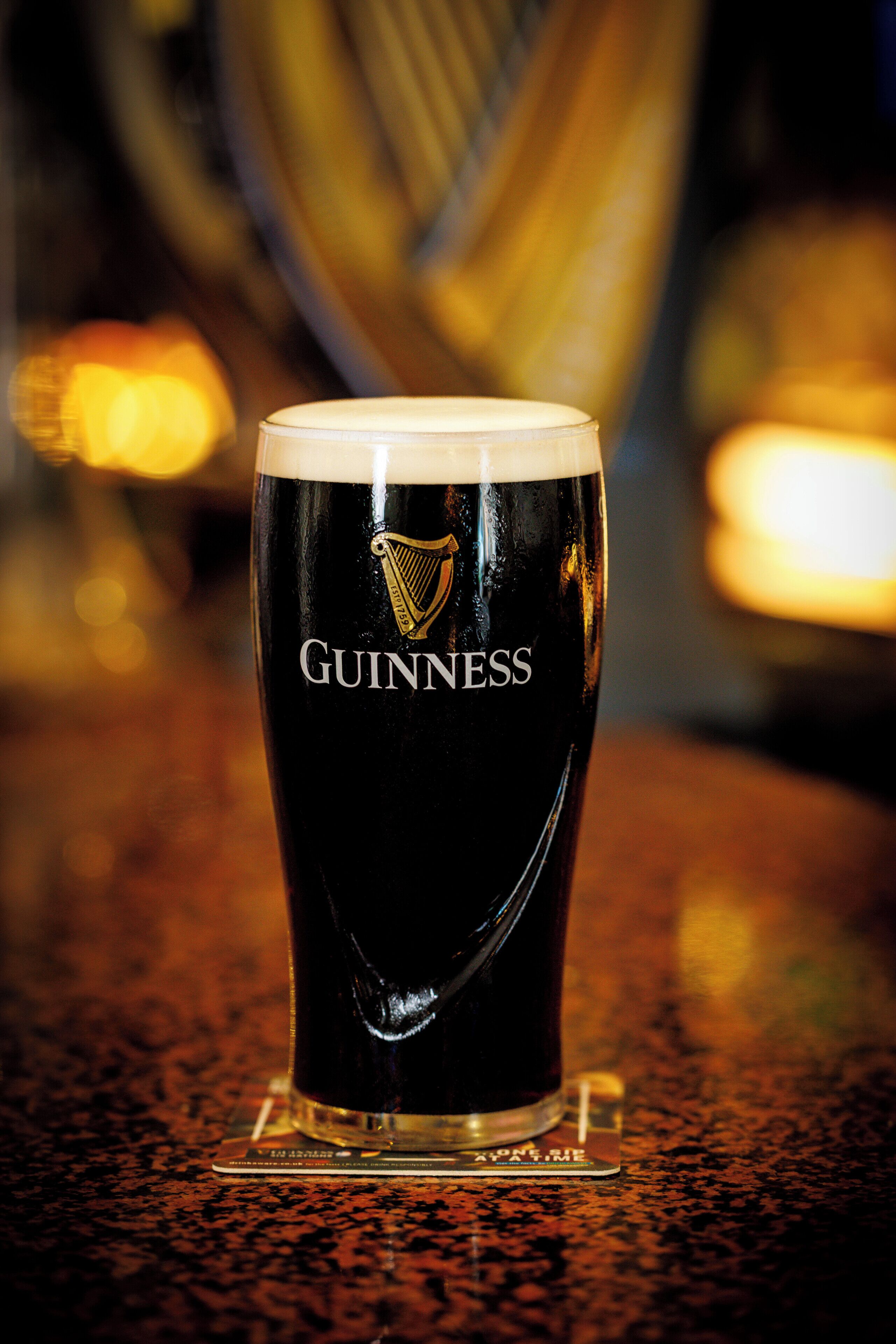 Un vaso de Guinness sobre un posavasos.