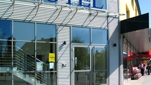 Un hotel con un llamativo letrero que dice 'HOTEL', amplias ventanas y una zona de acceso cubierta.