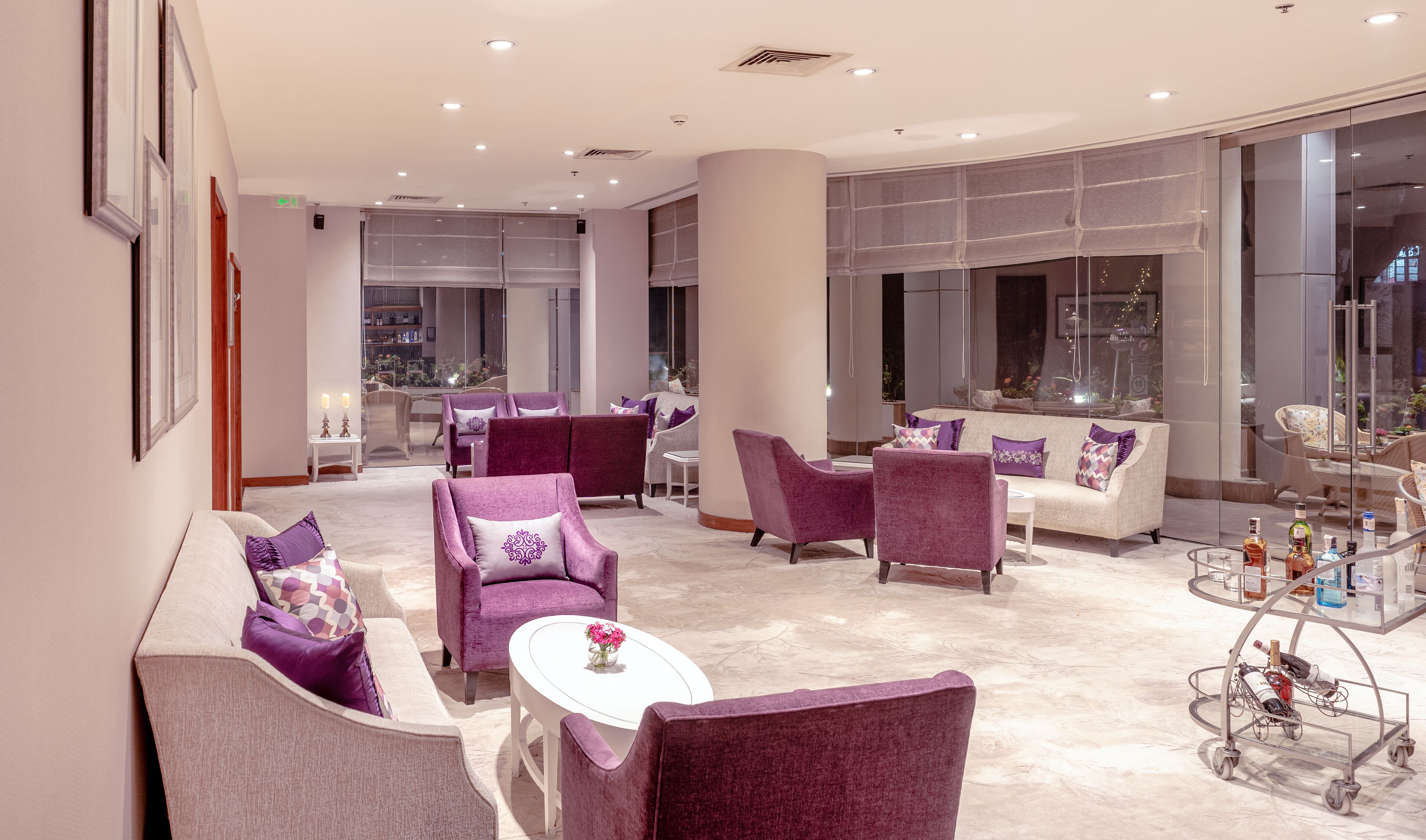 A spacious lounge area with multiple seating options, including sofas and armchairs, arranged around a central coffee table.