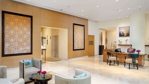 A modern lobby with a reception desk, seating area, and a patterned wall. - Taj Wellington Mews Luxury Residences (Mumbai)